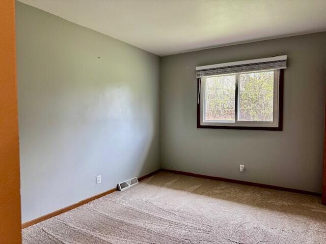 unfurnished room with visible vents, carpet flooring, and baseboards