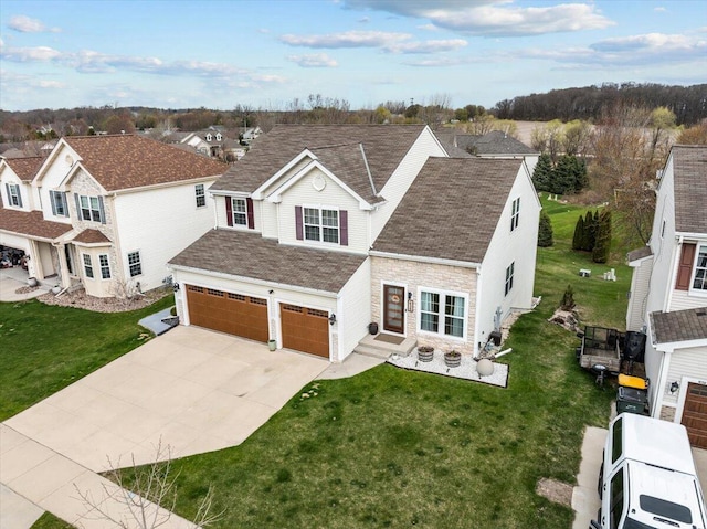 630 Polaris St, West Bend, WI 53095 - traditional-style house featuring driveway, a residential view, a front lawn, an attached garage, and stone siding