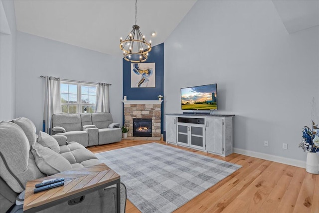 630 Polaris St, West Bend, WI 53095 - living area with light wood-style floors, high vaulted ceiling, a fireplace, and a chandelier