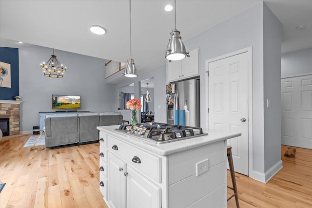 630 Polaris St, West Bend, WI 53095 - kitchen featuring light wood-style floors, white cabinets, stainless steel appliances, and open floor plan