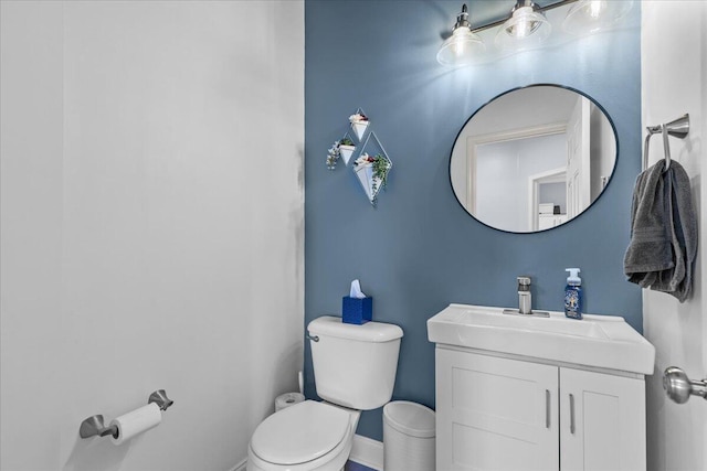 630 Polaris St, West Bend, WI 53095 - half bath featuring toilet, baseboards, and vanity