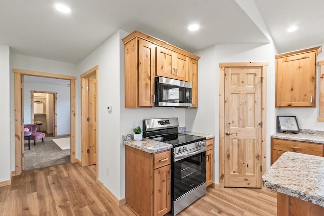 kitchen with light countertops, light wood-style flooring, and appliances with stainless steel finishes