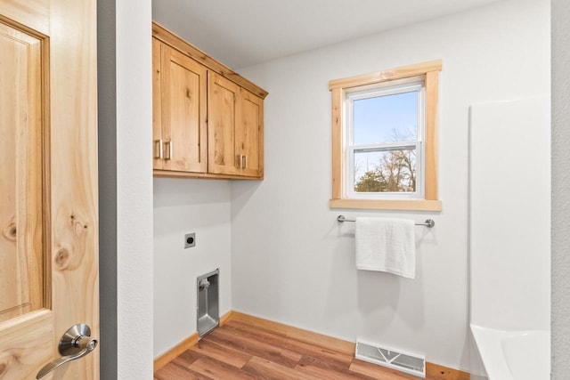 clothes washing area with cabinet space, baseboards, light wood-type flooring, hookup for an electric dryer, and visible vents