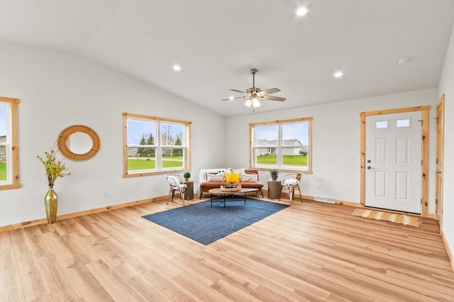 living room with a ceiling fan, baseboards, vaulted ceiling, and light wood-type flooring