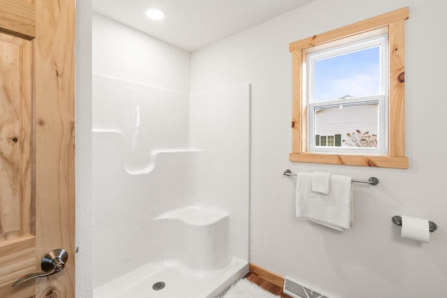 bathroom with baseboards and walk in shower
