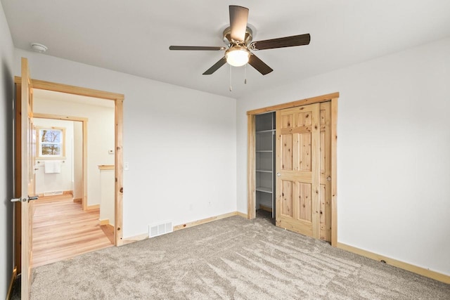 unfurnished bedroom featuring baseboards, a ceiling fan, carpet flooring, and visible vents