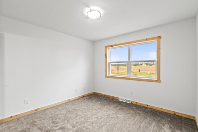spare room featuring baseboards, carpet, and visible vents