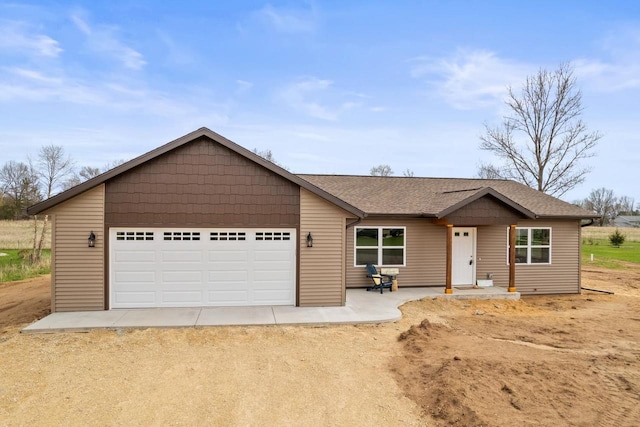 ranch-style home featuring a garage, dirt driveway, and a shingled roof