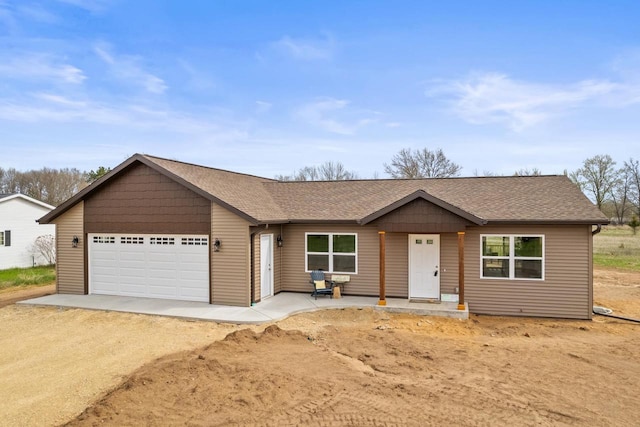 single story home with a shingled roof, an attached garage, and driveway