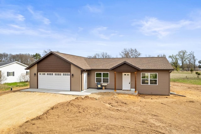 single story home featuring an attached garage, driveway, and a shingled roof