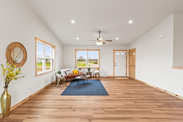 living area featuring baseboards, light wood finished floors, vaulted ceiling, and recessed lighting