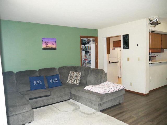 living area with baseboards and wood finished floors