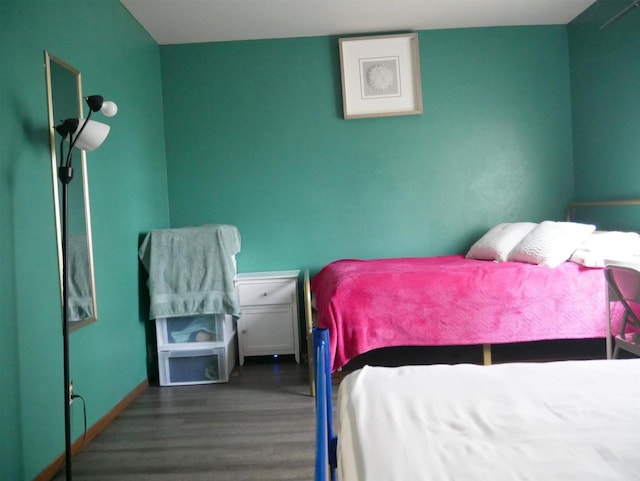 bedroom featuring baseboards and wood finished floors