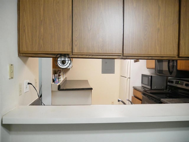 kitchen with electric panel, stainless steel appliances, and brown cabinetry