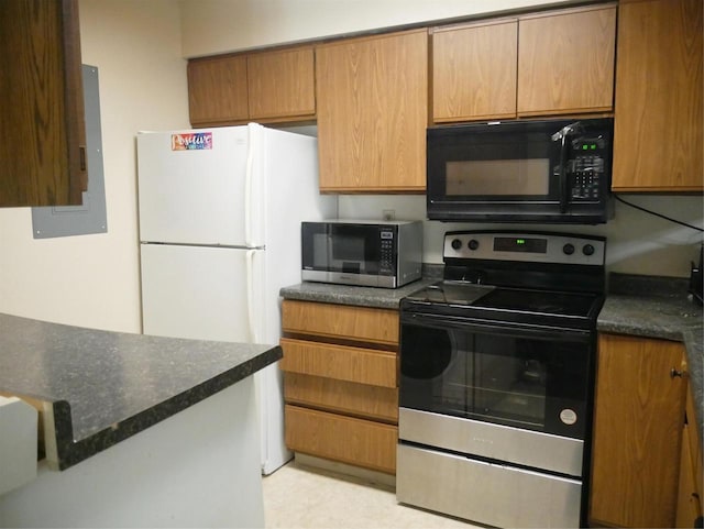kitchen featuring appliances with stainless steel finishes, brown cabinetry, and dark stone countertops