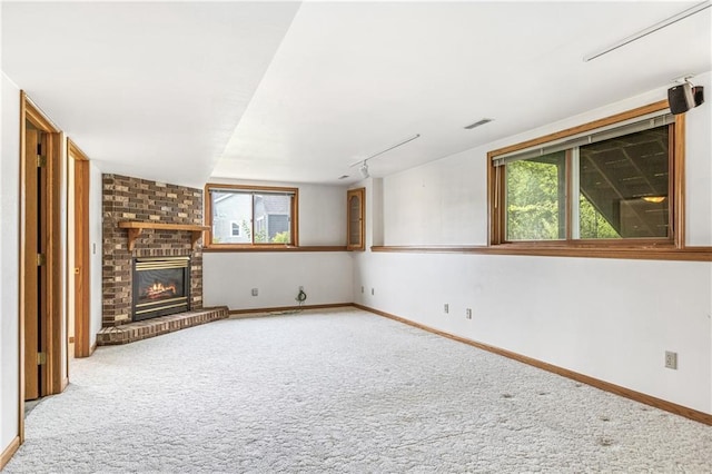 323 Hewitt St, Eau Claire, WI 54701 - unfurnished living room with carpet flooring, plenty of natural light, a brick fireplace, and baseboards