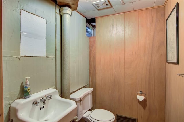 2015 Valmont Ave, Eau Claire, WI 54701 - bathroom featuring a sink, wood walls, toilet, and visible vents