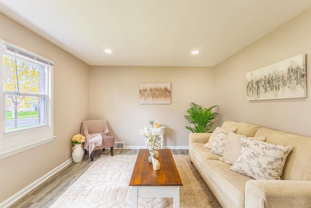 living room with baseboards, recessed lighting, wood finished floors, and visible vents