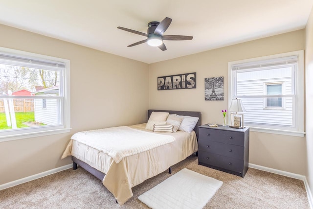 carpeted bedroom featuring baseboards and a ceiling fan