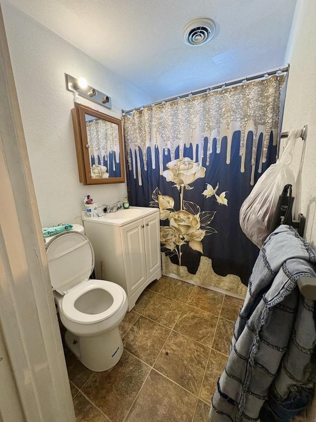 bathroom featuring visible vents, vanity, curtained shower, toilet, and tile patterned floors