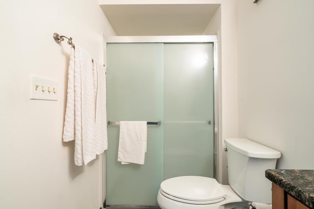 bathroom with vanity, a stall shower, and toilet