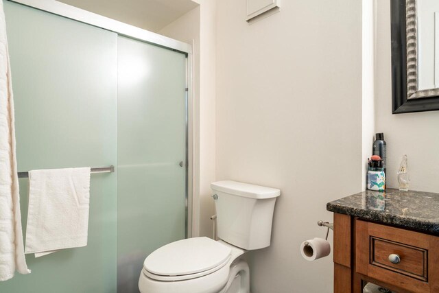 full bathroom with vanity, toilet, and a stall shower
