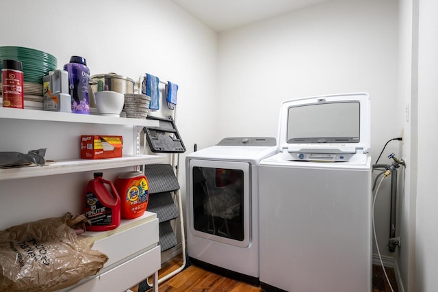 washroom featuring washing machine and clothes dryer, laundry area, and wood finished floors