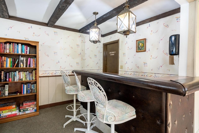 bar with a bar, wallpapered walls, beam ceiling, and a wainscoted wall