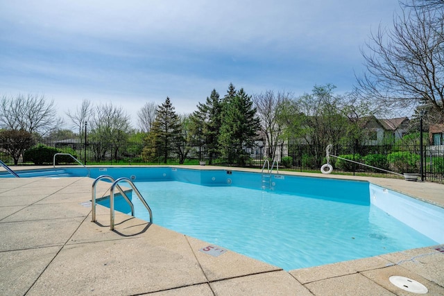 community pool with fence and a patio area