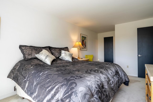 bedroom featuring baseboards and light carpet