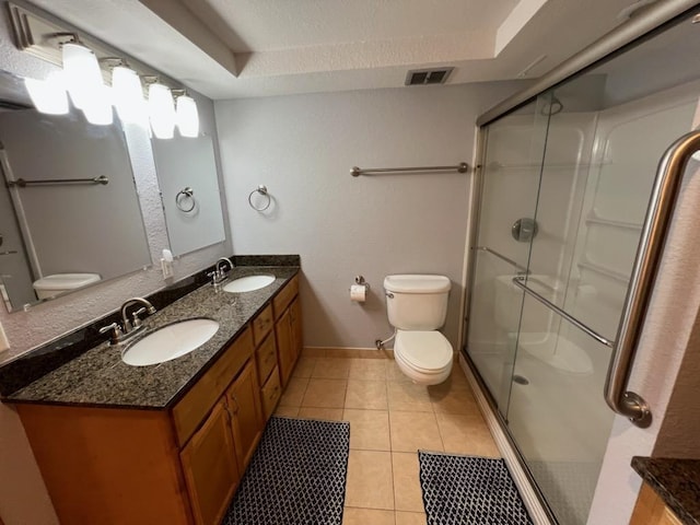 bathroom featuring visible vents, a sink, a stall shower, and toilet