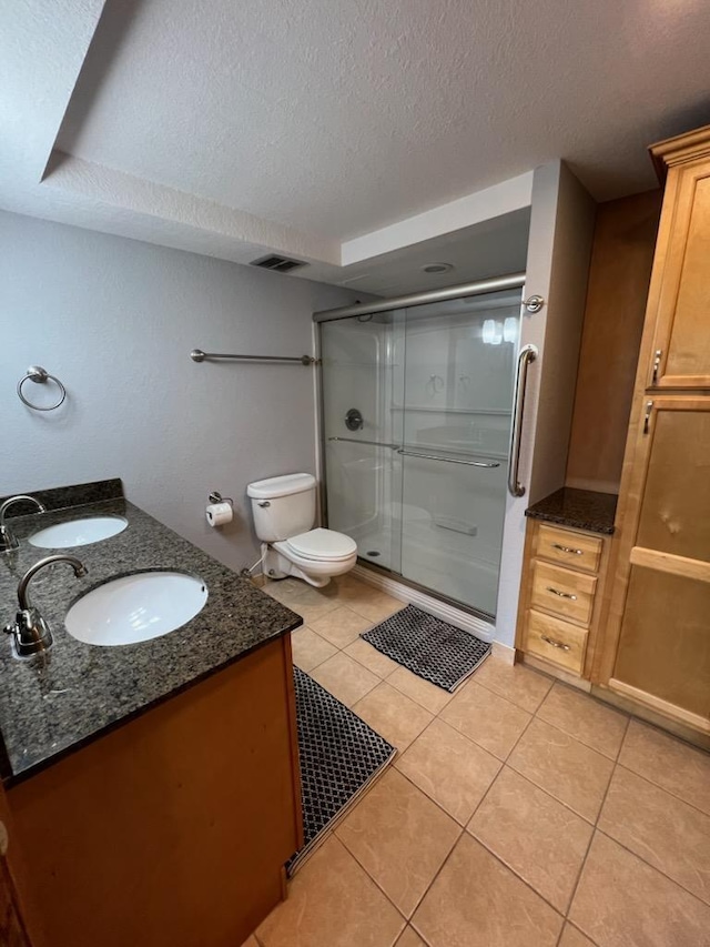 bathroom with a sink, a textured ceiling, tile patterned floors, and a shower stall