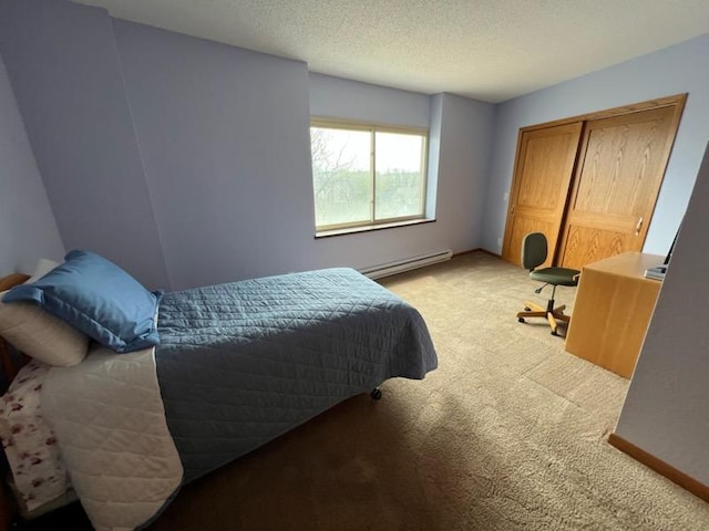 bedroom with a closet, a baseboard radiator, a textured ceiling, and light carpet