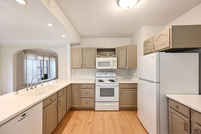 kitchen featuring a sink, white appliances, arched walkways, light wood-style flooring, and recessed lighting