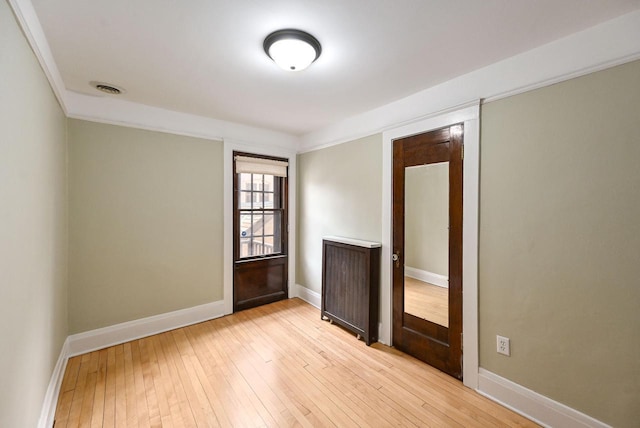 empty room with baseboards, light wood-style flooring, and visible vents