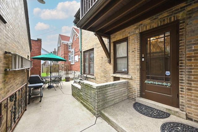 entrance to property with brick siding and outdoor dining area