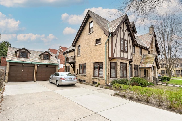 view of property exterior featuring brick siding, driveway, and a chimney