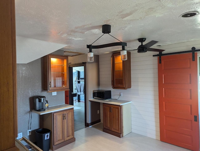 4464 S Whitnall Ave, Milwaukee, WI 53225 - kitchen with a barn door, a textured ceiling, stainless steel microwave, and light countertops