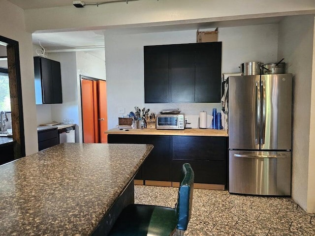 4464 S Whitnall Ave, Milwaukee, WI 53225 - kitchen with dark countertops, dark cabinetry, freestanding refrigerator, a toaster, and modern cabinets