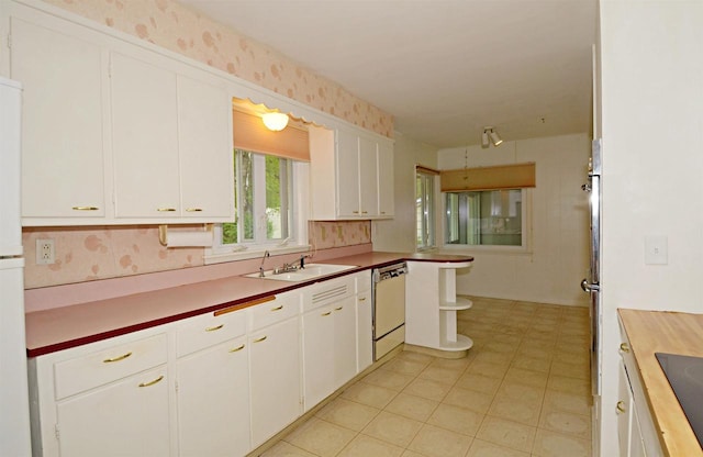 5109 Whitcomb Dr, Madison, WI 53711 - kitchen featuring dishwasher, a sink, white cabinets, wallpapered walls, and black electric cooktop
