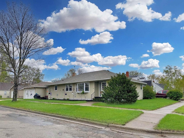 ranch-style home featuring a chimney, an attached garage, and a front lawn