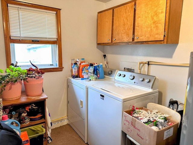 washroom with baseboards, cabinet space, and washing machine and clothes dryer