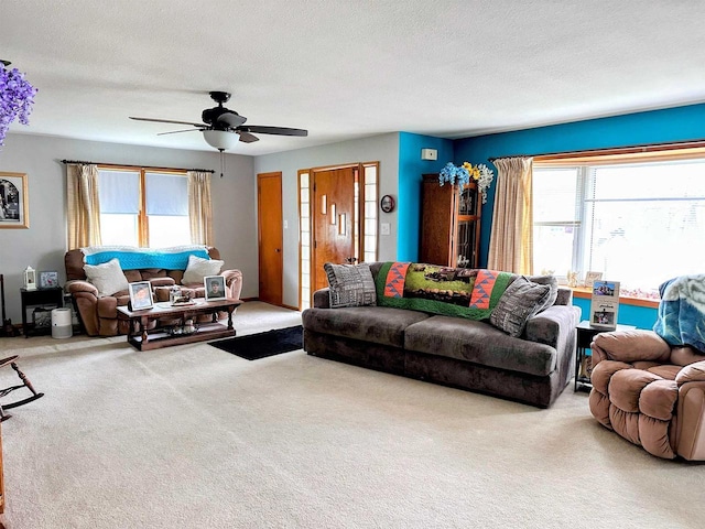 carpeted living room featuring a textured ceiling and ceiling fan