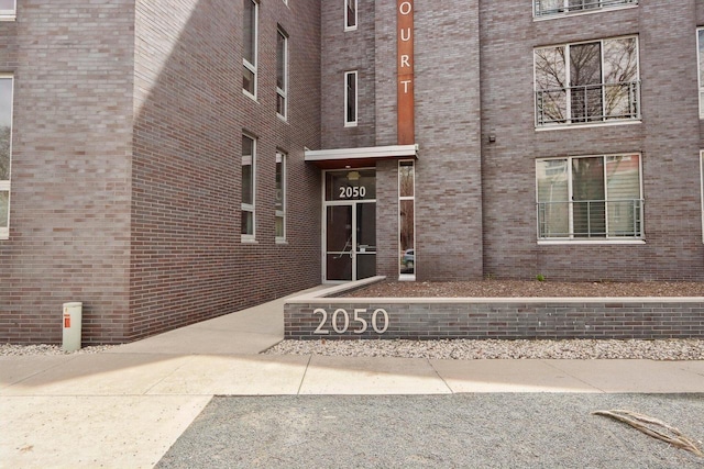 doorway to property featuring brick siding