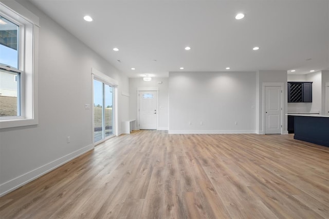 223 NW 3rd Ave, Monroe, WI 53566 - unfurnished living room featuring recessed lighting, baseboards, and light wood-style flooring