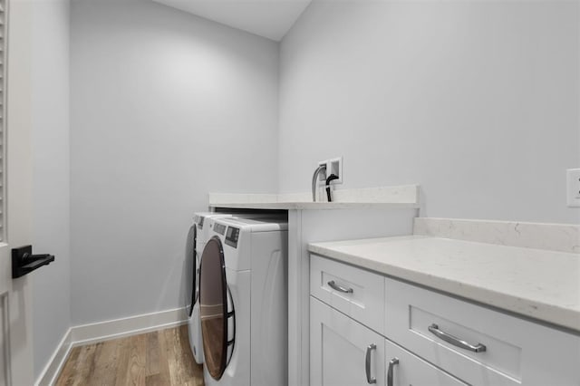 255 NW 3rd Ave, Monroe, WI 53566 - washroom featuring independent washer and dryer, baseboards, cabinet space, and light wood-style floors