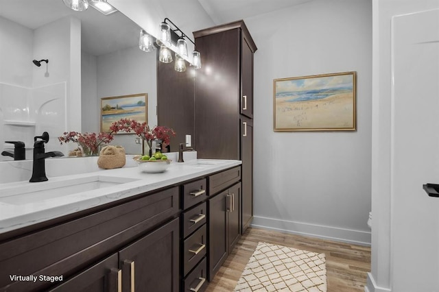 255 NW 3rd Ave, Monroe, WI 53566 - full bathroom featuring a sink, a shower, and wood finished floors
