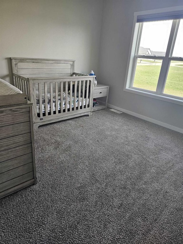 456 N Hyland St, Juneau, WI 53039 - carpeted bedroom with baseboards and a nursery area
