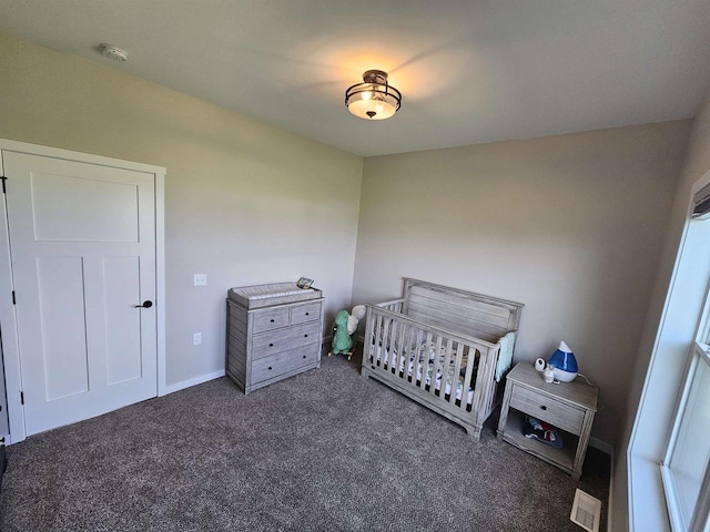 456 N Hyland St, Juneau, WI 53039 - bedroom featuring dark colored carpet, a crib, and baseboards