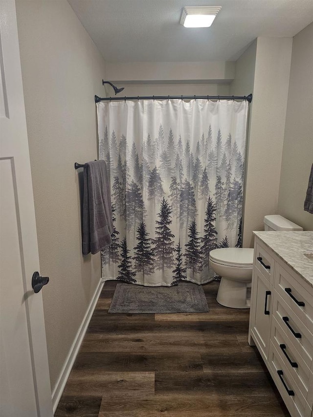 456 N Hyland St, Juneau, WI 53039 - full bathroom featuring wood finished floors, toilet, a shower with shower curtain, and baseboards
